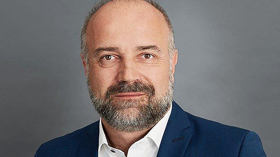 A person looks into the camera with a smile